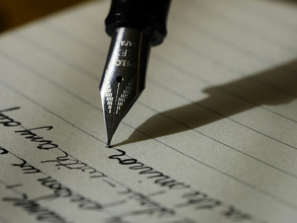 Fountain pen writing research notes on lined paper, representing academic writing, thesis development, dissertation writing and research support services.