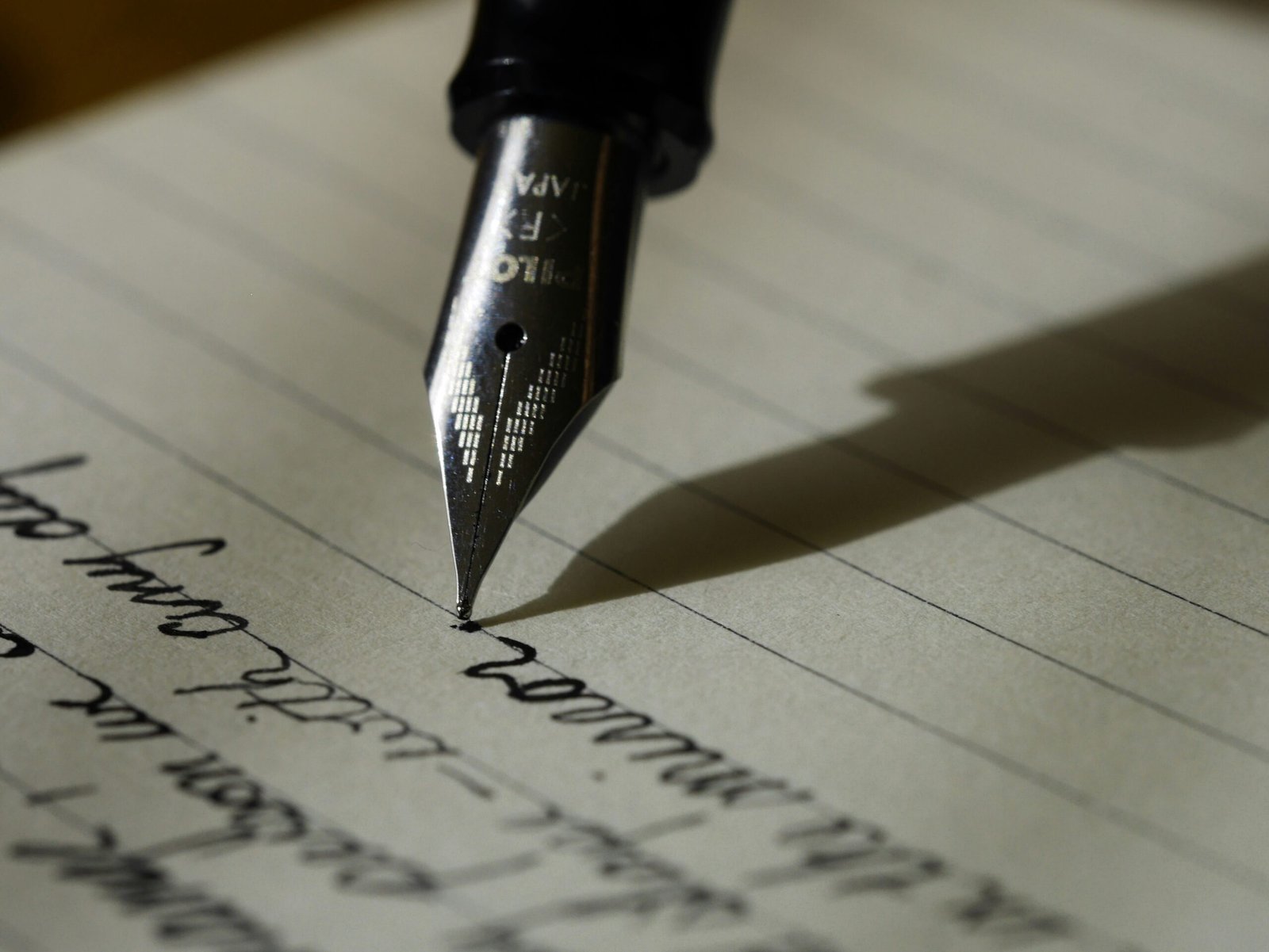 Fountain pen writing research notes on lined paper, representing academic writing, thesis development, dissertation writing and research support services.