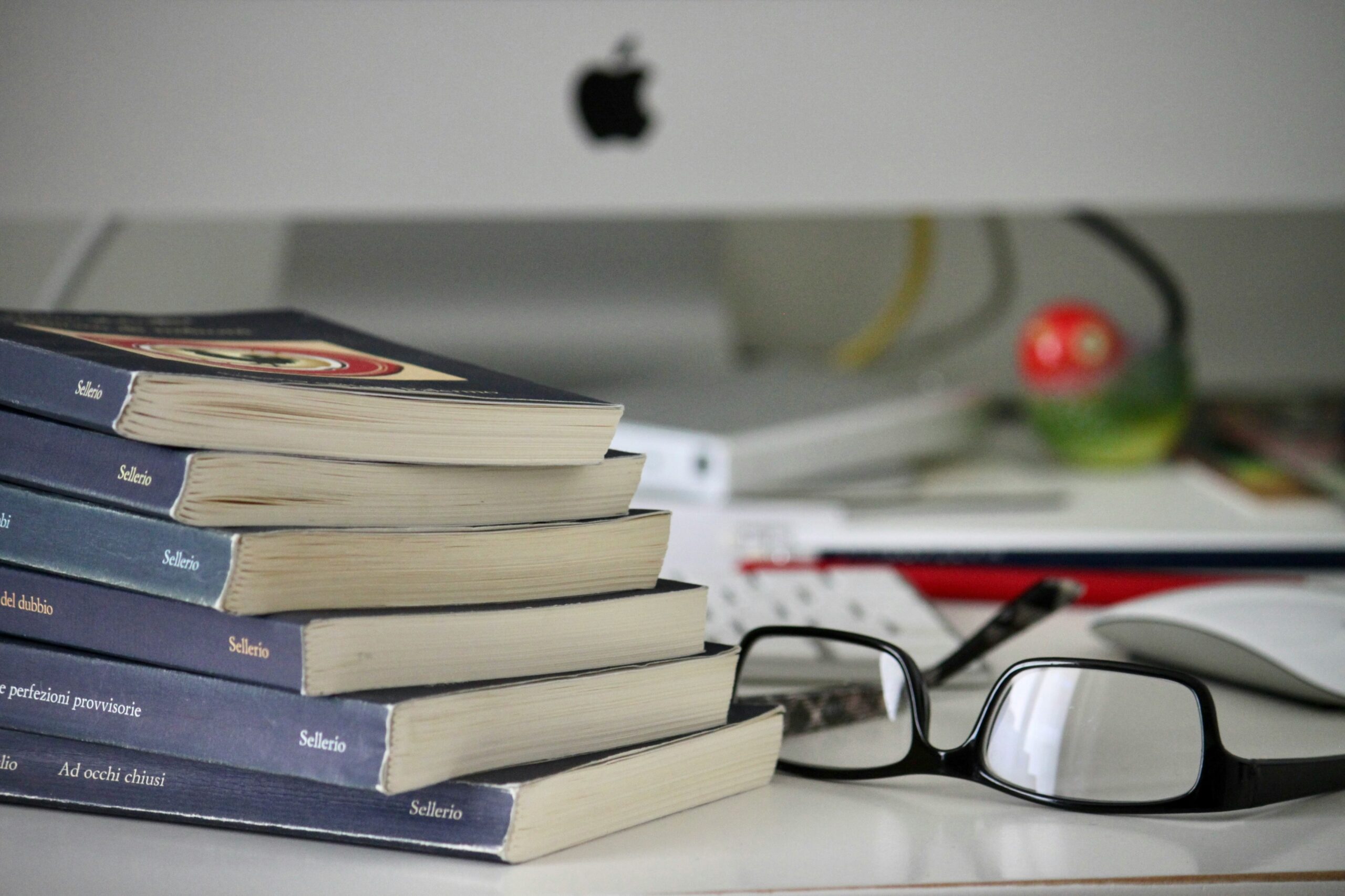 Stack of books for a dissertation literature review on a scholar's desk