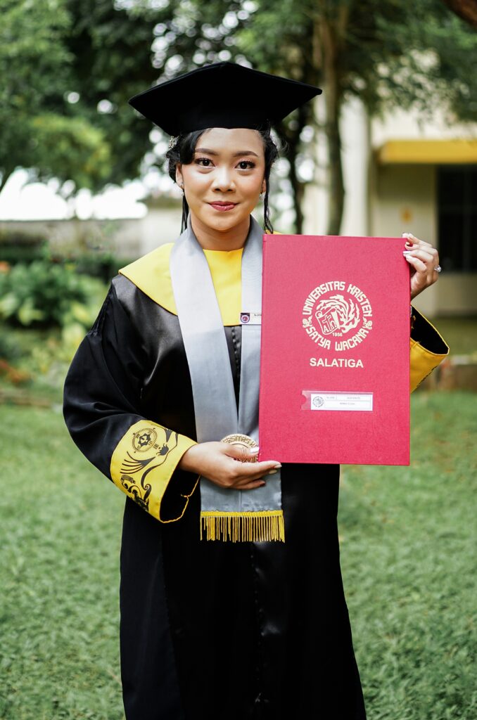 Smiling university graduate with a diploma, highlighting the best PhD thesis services for scholars and researchers.